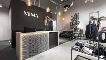 Prodajni pult v trgovini Mima Fashion Store s kovinsko mrežo, lesenim ogrodjem in osvetlitvijo