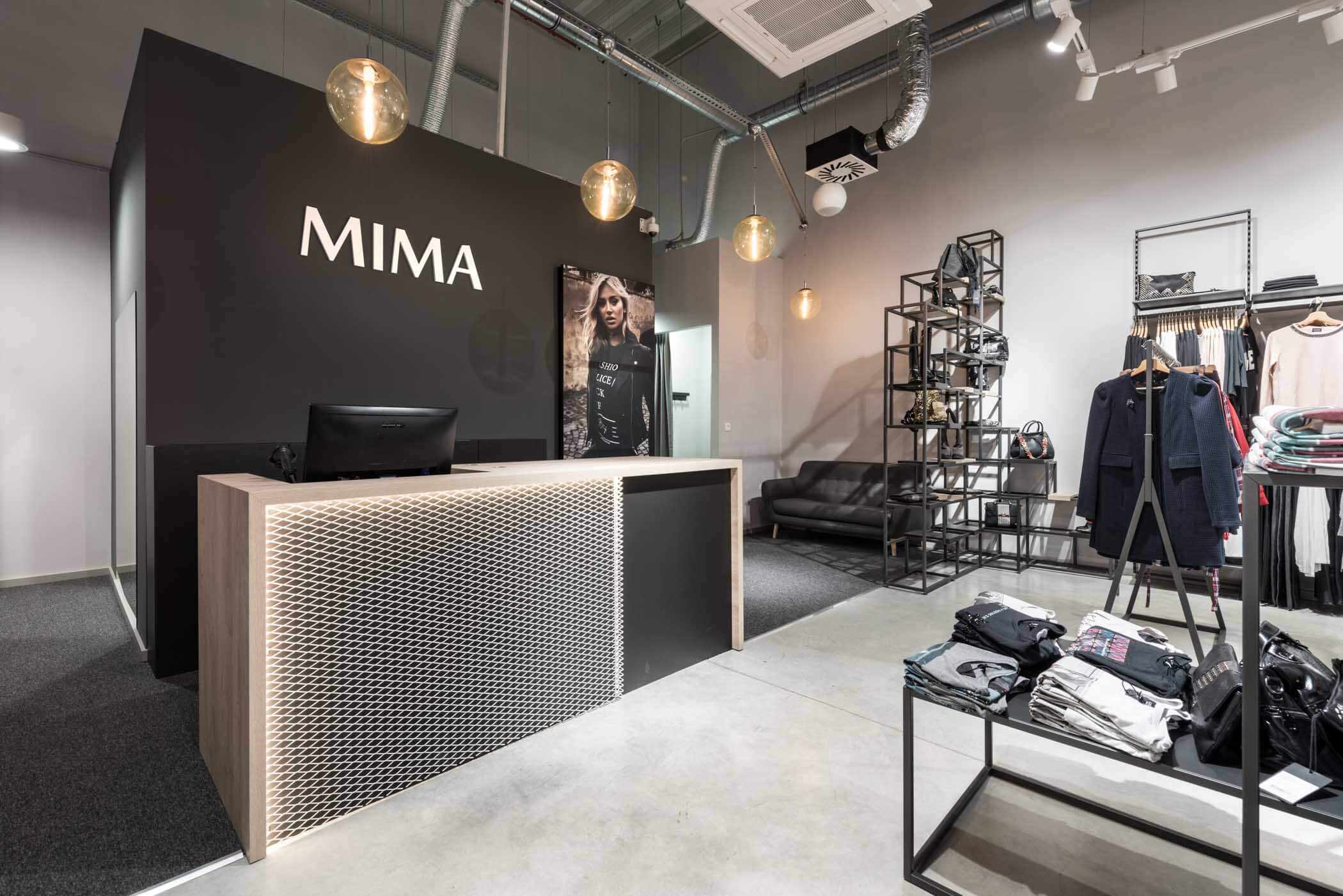 Prodajni pult v trgovini Mima Fashion Store s kovinsko mrežo, lesenim ogrodjem in osvetlitvijo