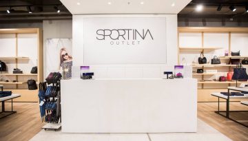 Prodajni pult v elegantni beli barvi v trgovini Sportina Outlet