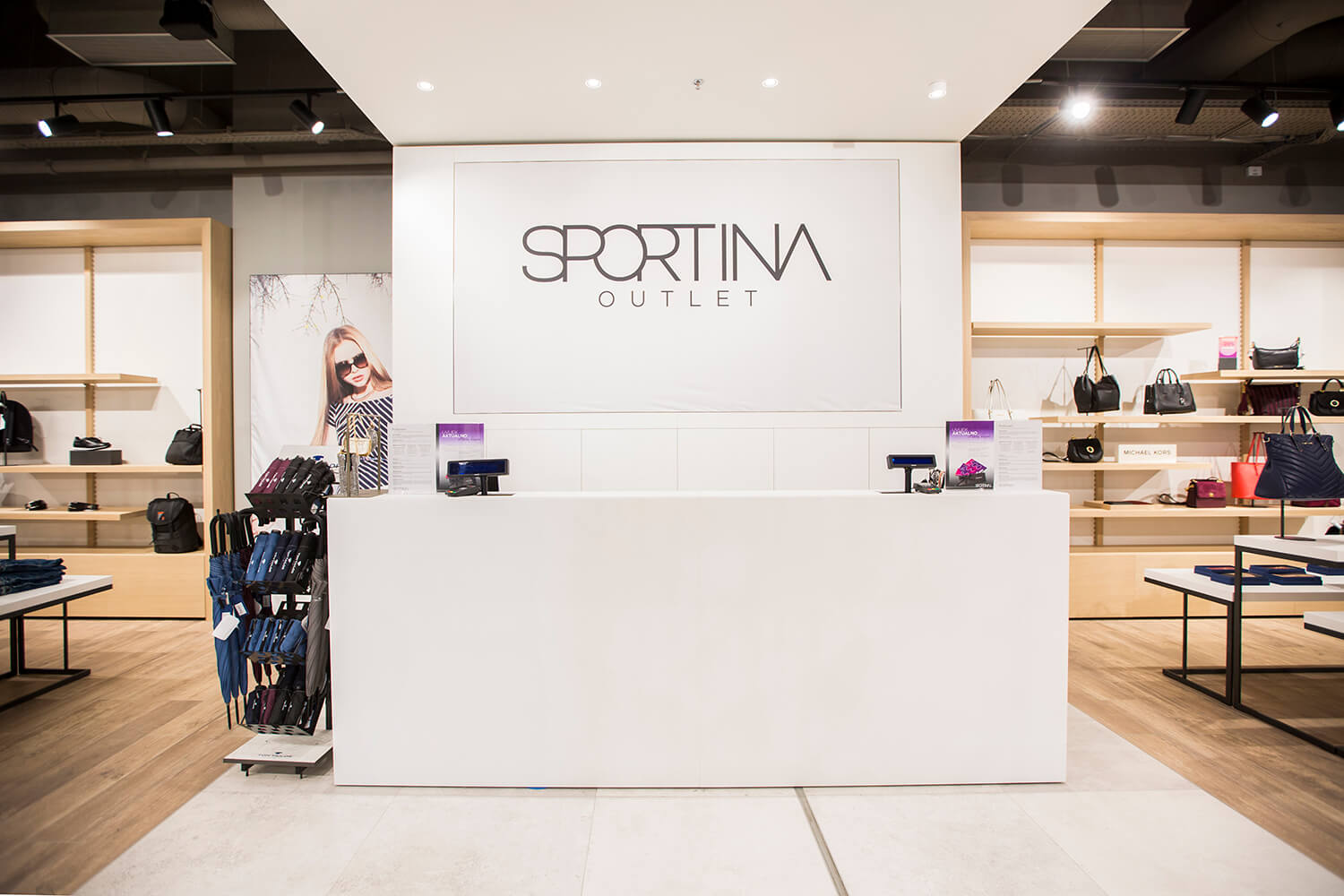 Prodajni pult v elegantni beli barvi v trgovini Sportina Outlet