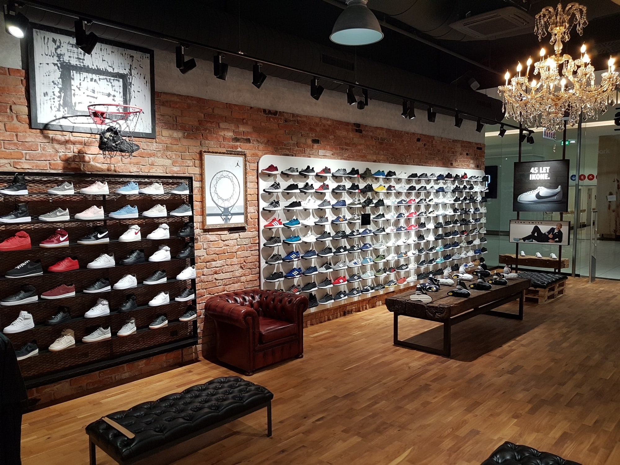 Razstavne police s supergi na opečnati steni v trgovini Sneakers