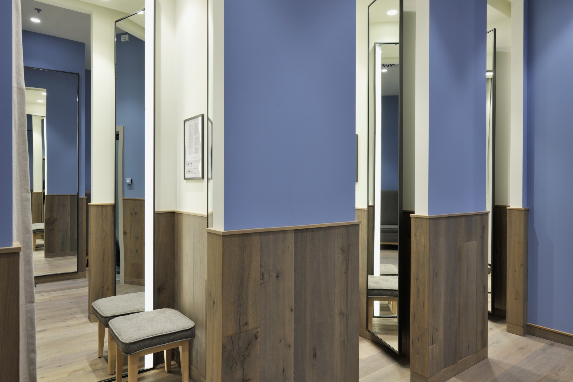 Dressing room in wood and blue walls in XYZ Villach store